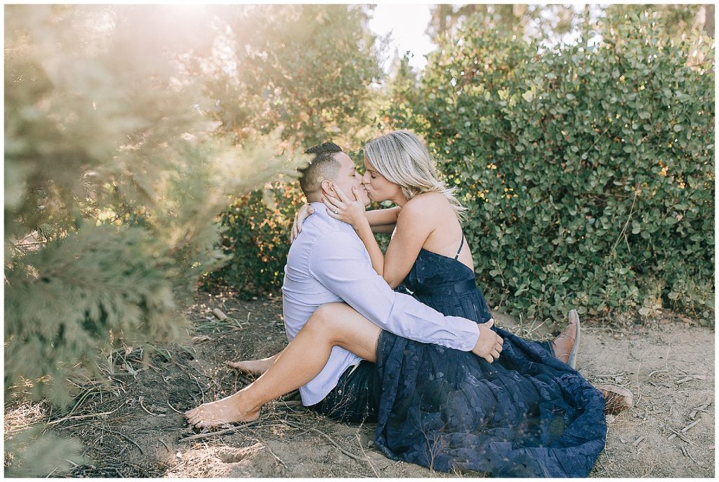 sitting and kissing engagement photo