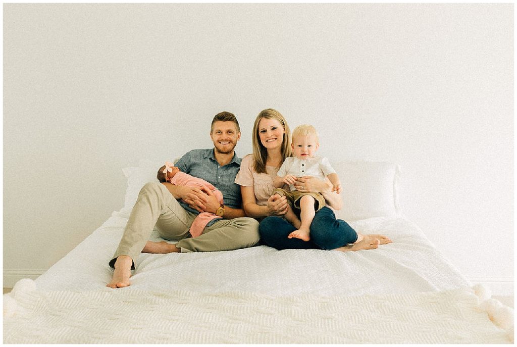 family newborn session sitting on bed