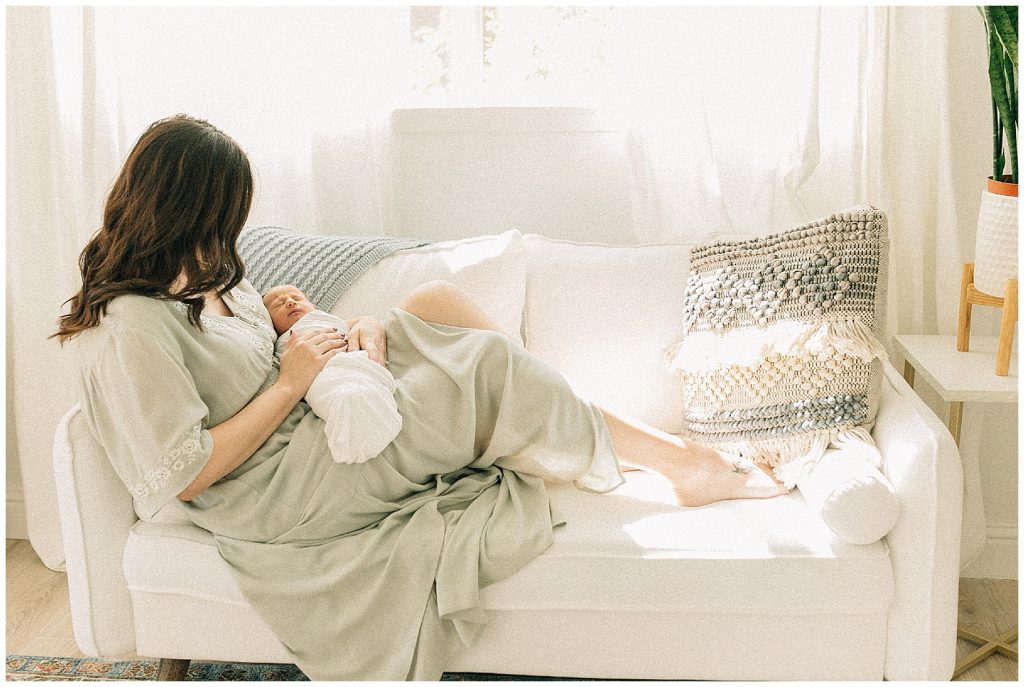 mom sitting on couch with her baby