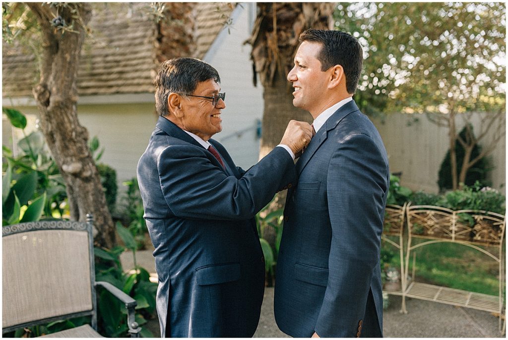 grooms dad putting tie on