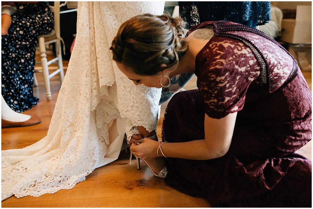 sister putting brides shoes on