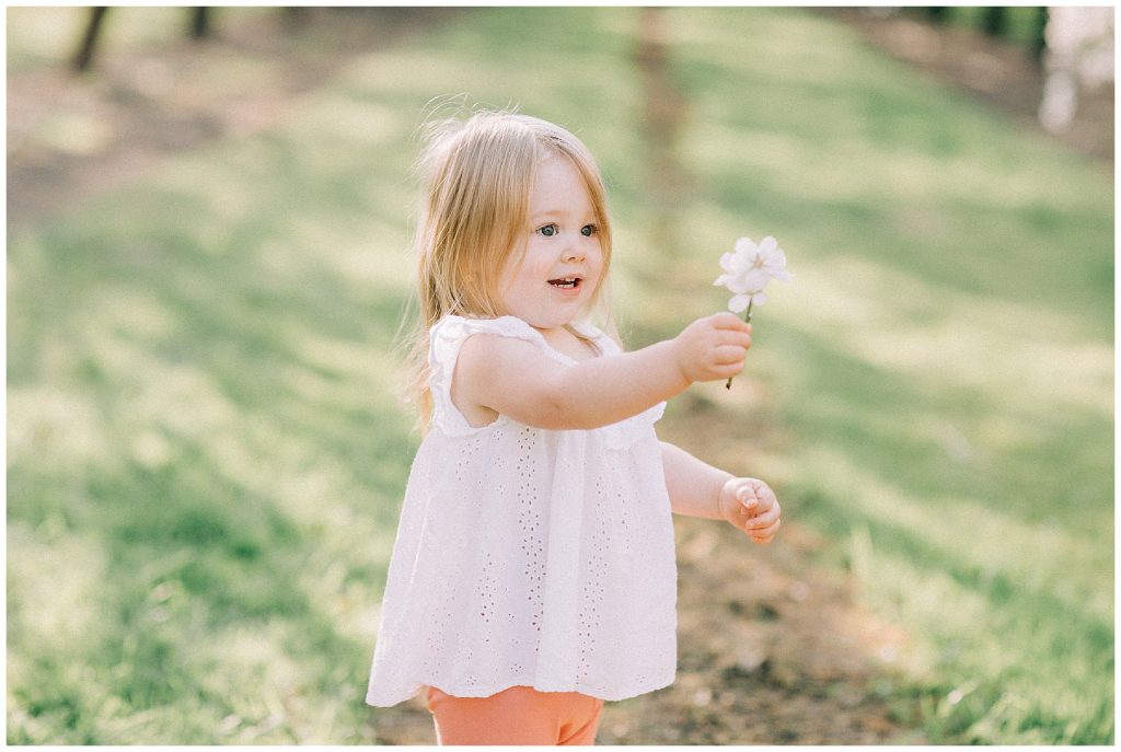 little girl playing with flowers