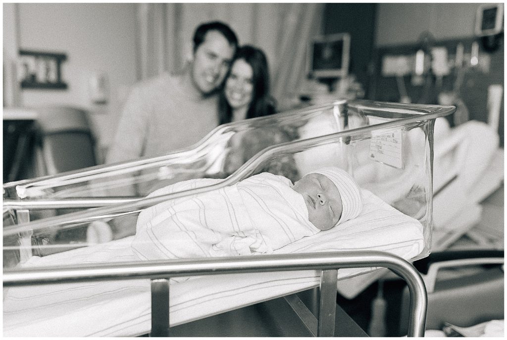 mom and dad with newborn baby in hospital 